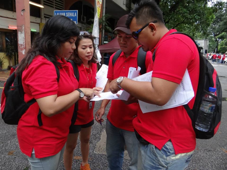 Team in red shirts completing a rope challenge